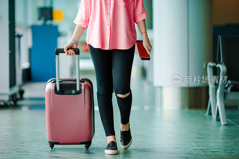 携带护照、登机牌和粉红色行李的旅客