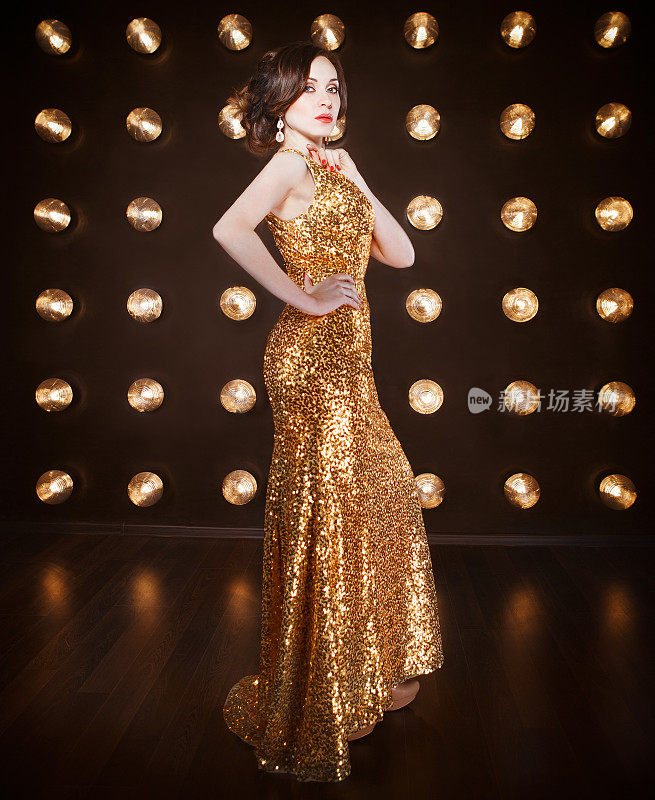 超级明星女人穿着金光闪闪的裙子