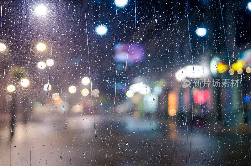 城市街灯透过窗户与雨滴