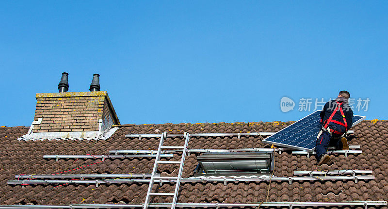 把太阳能板放在屋顶上的人