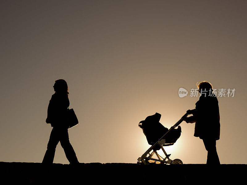 日落时分，母亲和祖母推着婴儿车