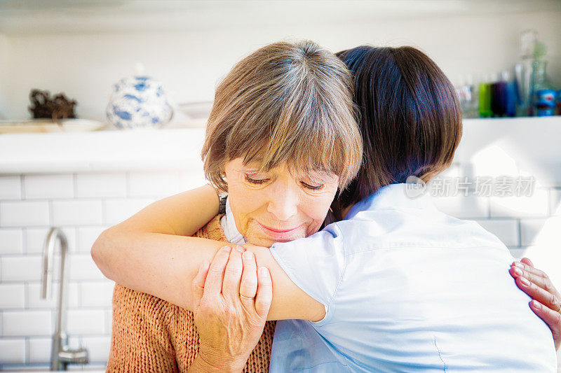 年迈的母亲在悲痛中拥抱女儿