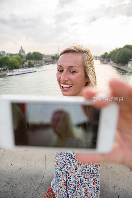 金发女人在巴黎的一座桥上自拍