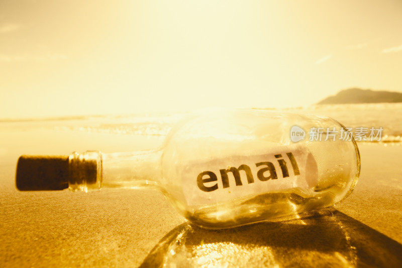 沐浴在夕阳的金色光芒下，瓶子里的信息写着电子邮件