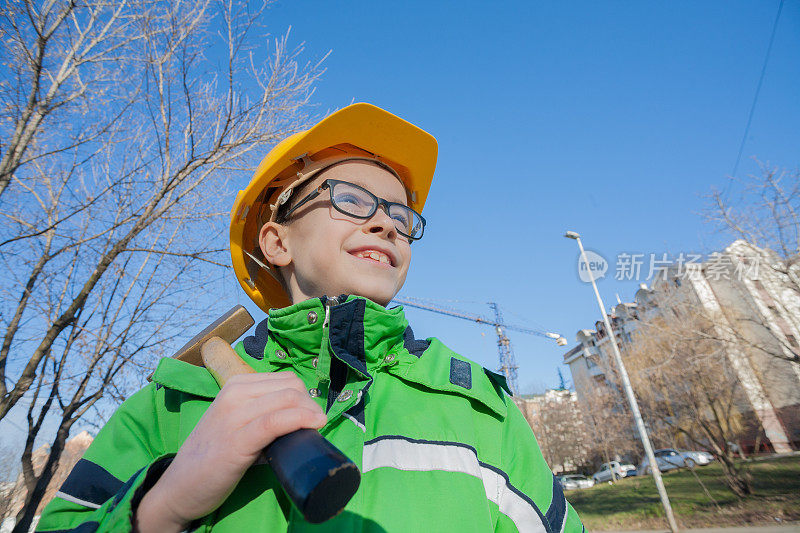 戴着黄色头盔和锤子的男建筑工人