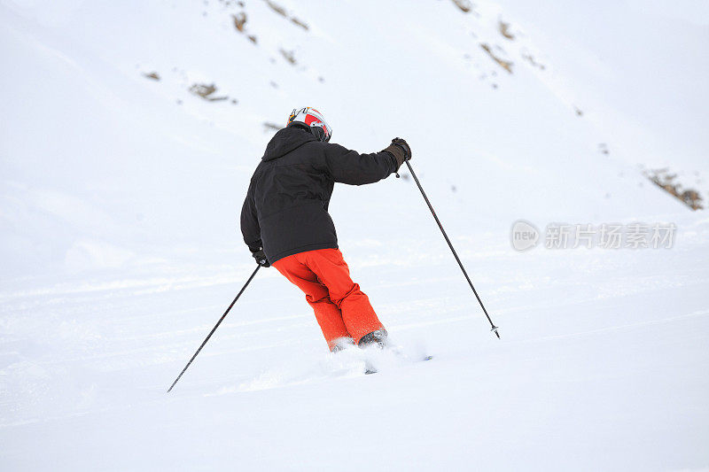 后视图男人在乡间滑雪，雪上有粉