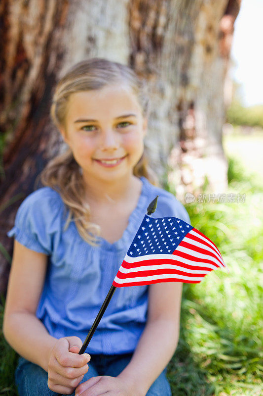 微笑的女孩挥舞着美国国旗
