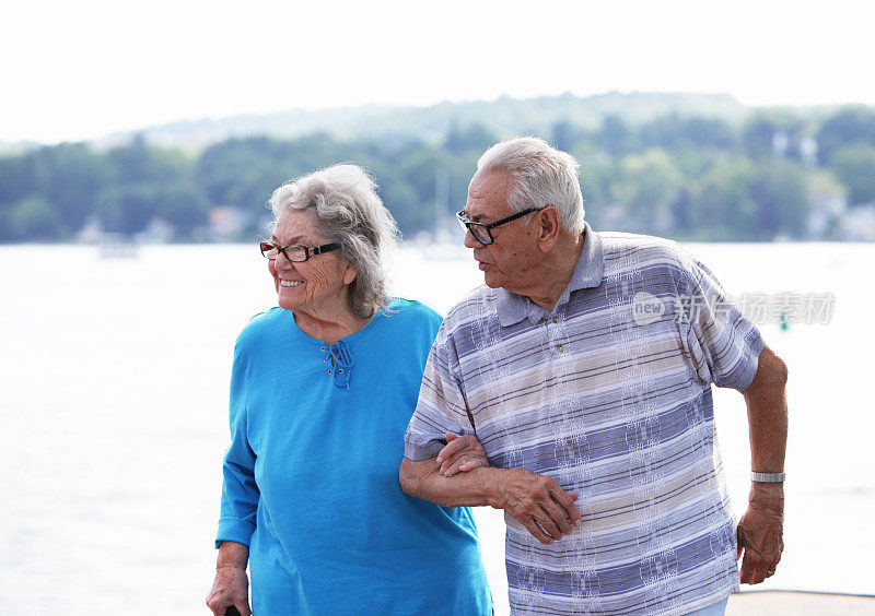 一对老年夫妇在湖边散步聊天