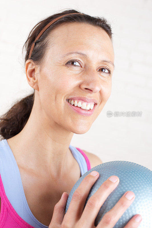 带着健身球微笑的中年妇女