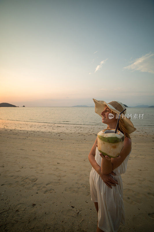 沙滩上抱着椰子的女人