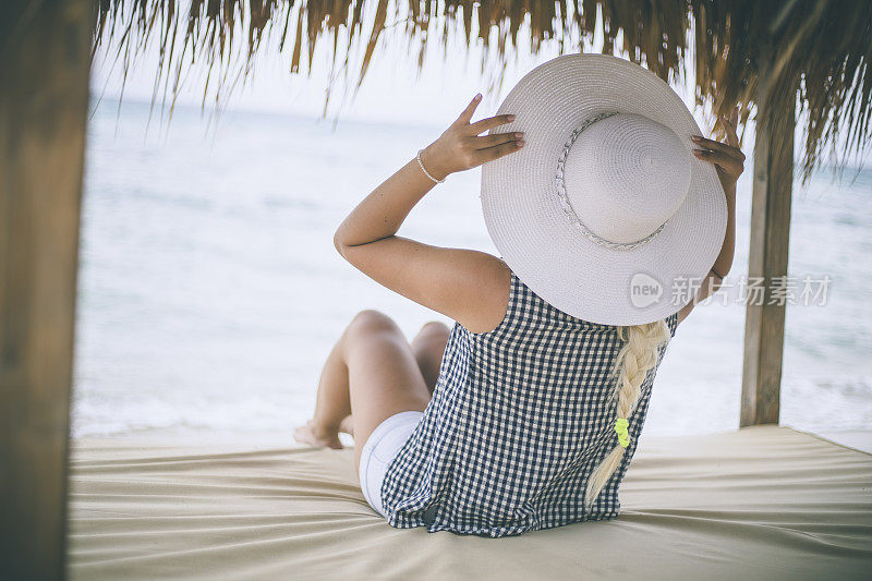 穿着夏装的女人望着天空和大海