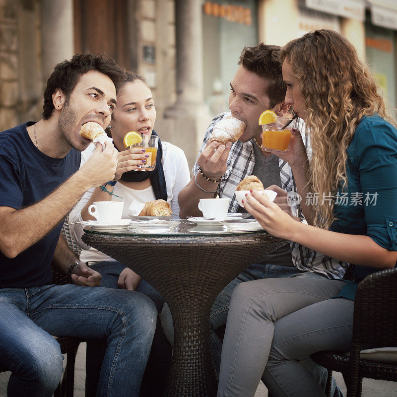 四个朋友在咖啡馆吃早餐。