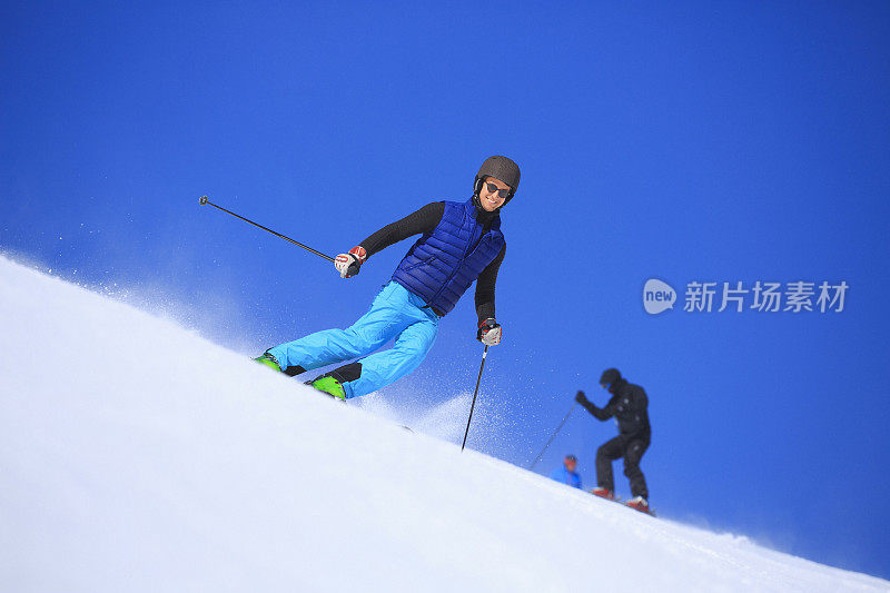 年轻人在阳光明媚的滑雪场滑雪