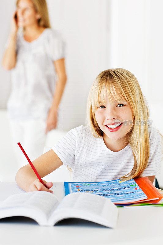 小女孩微笑着做作业