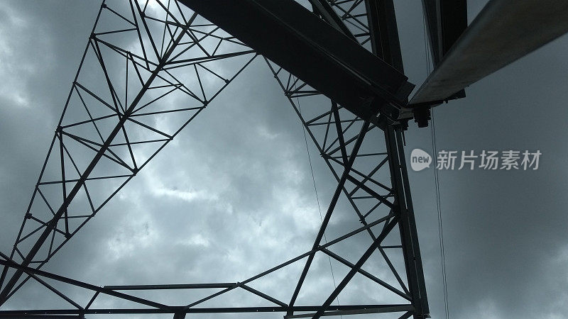 蛙视图从电力线塔柱下的暴风雨云