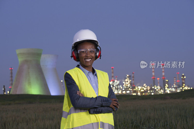 化学工程师女人在化石燃料发电厂黄昏时间。