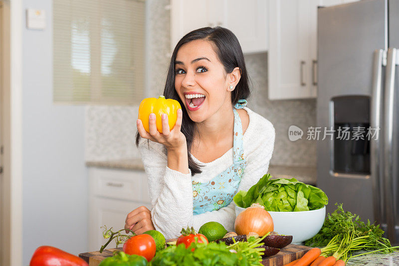 年轻的西班牙妇女拿着甜椒准备一顿饭