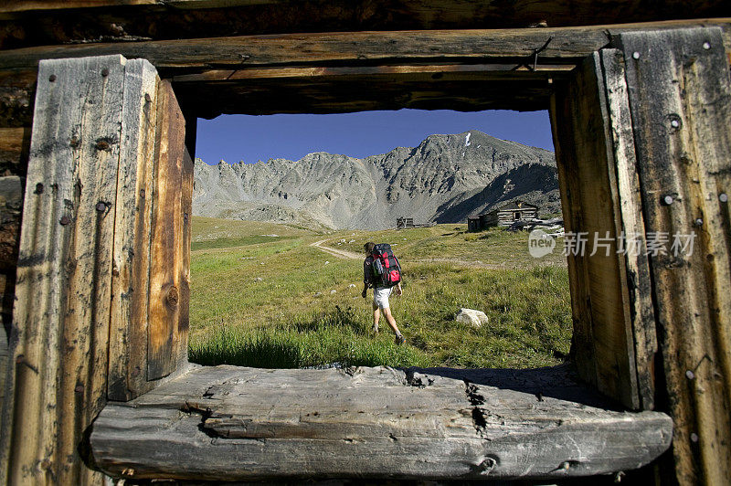 透过小木屋的窗户，山里的徒步旅行者
