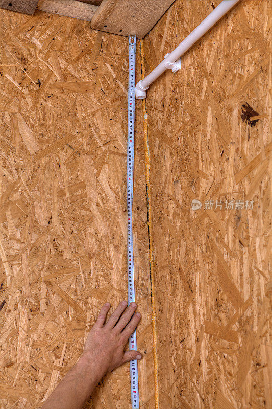 安装家用管道，用卷尺测量距离。