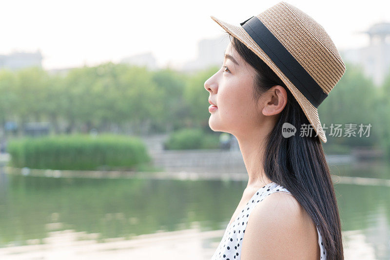 一个快乐的女人站在湖边的肖像