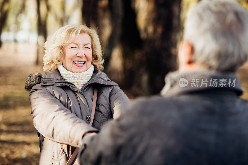 快乐的老夫妇手牵着手在公园里