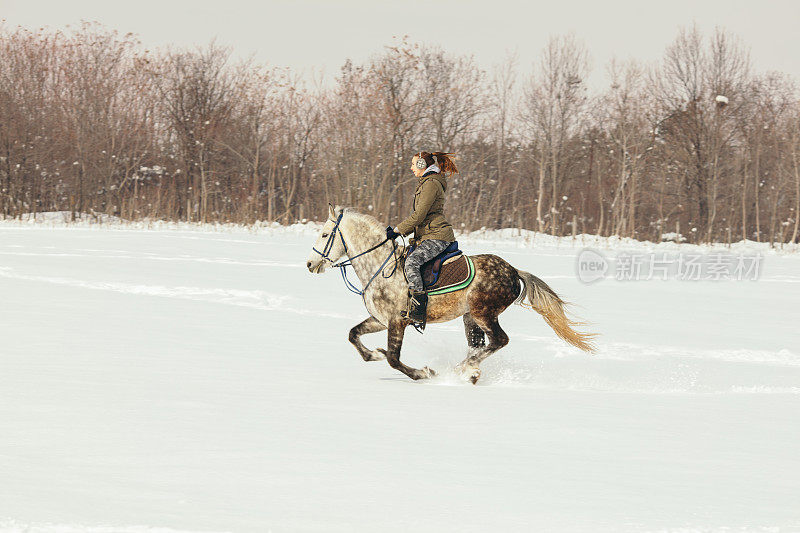 一个女人在雪地里骑马