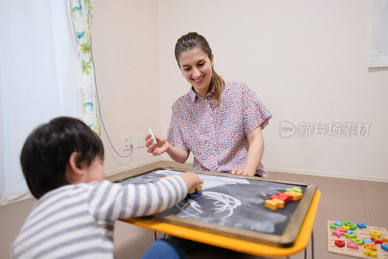 白人妇女用黑板教小孩英语