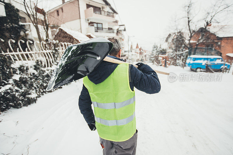 成熟的男人拿着雪铲