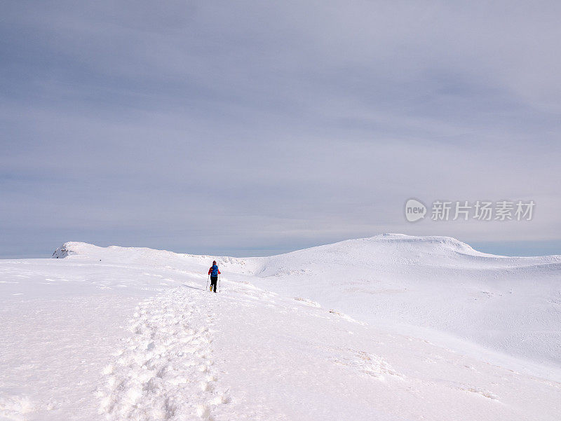 女性登山者在冬季攀登高海拔的山峰