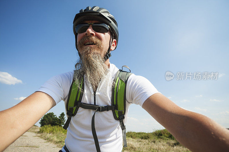 长胡子的男人在户外骑山地车