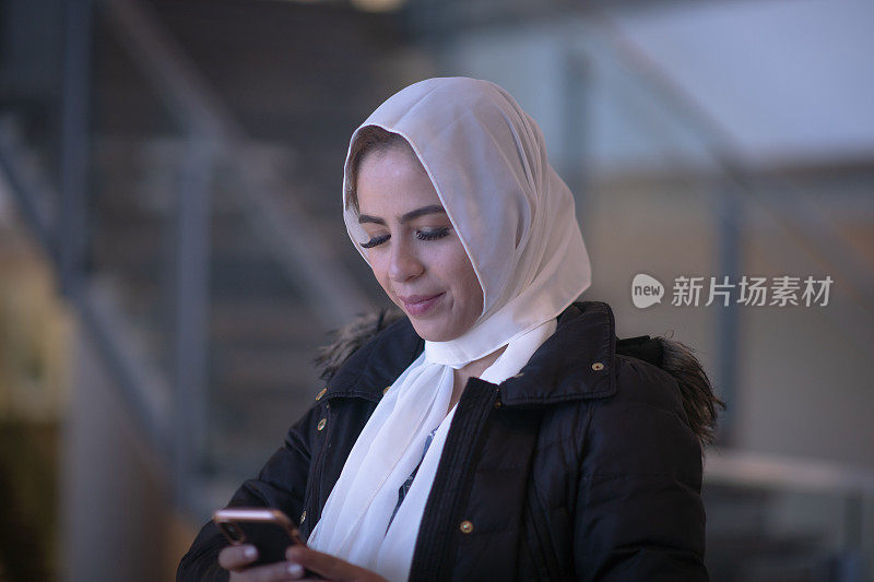 一名穆斯林妇女在机场的库存照片中等待