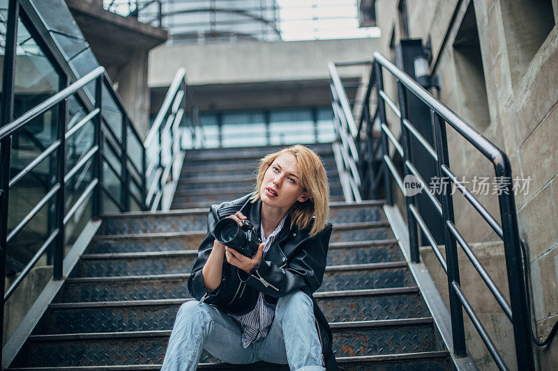 年轻漂亮的女人坐在楼梯上拍照