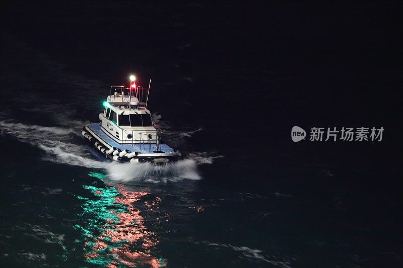 海上领航员在夜间与彩色反射水面