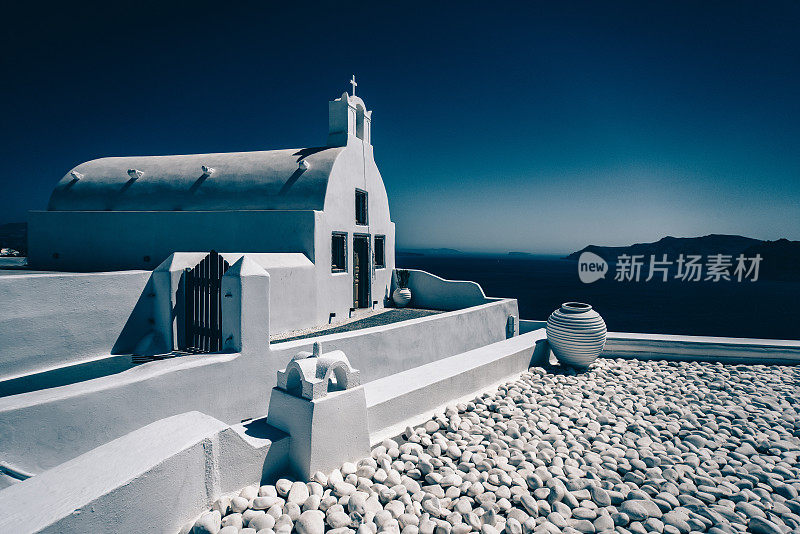 希腊圣托里尼白色教堂顶上的小石砌庭院
