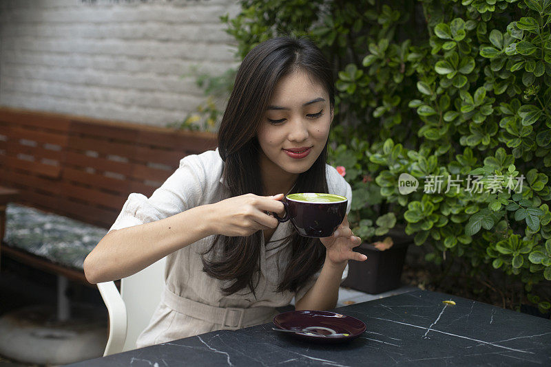 美丽的年轻女子正在喝茶