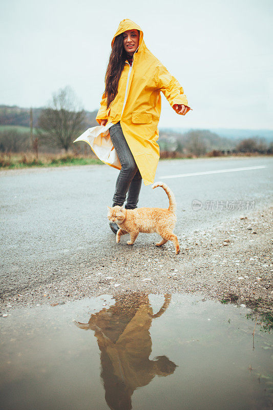 快乐的女孩和猫在大自然的雨