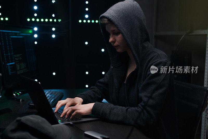 女性电脑黑客在显示器的背景键盘上编码。女性电脑黑客在显示器的背景键盘上编码。