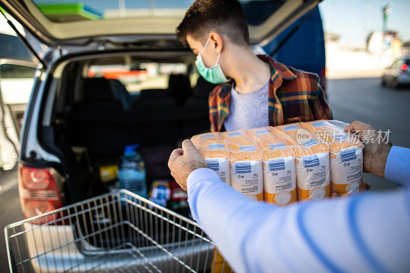 在病毒流行的时刻，一个十几岁的男孩帮助父亲在汽车后备箱里装面粉