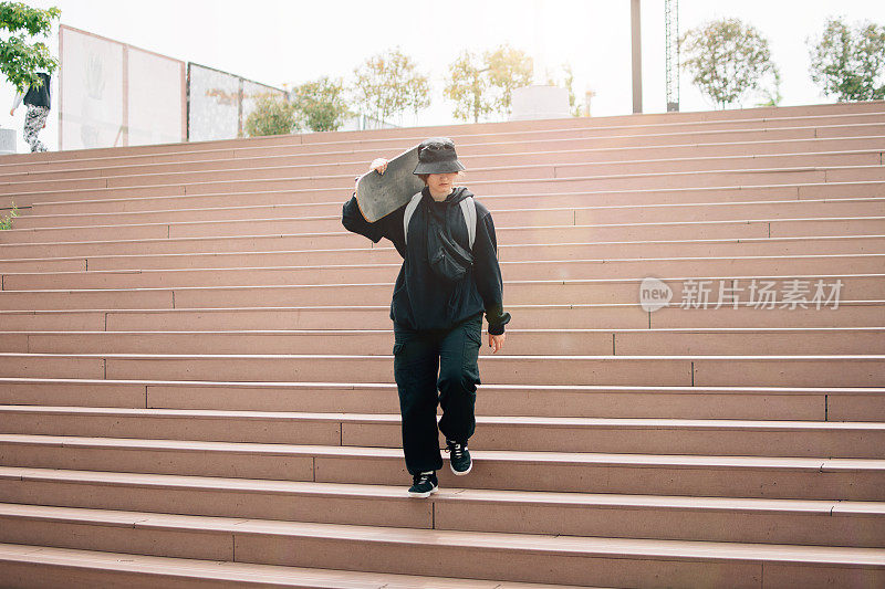 在阳光明媚的天气里玩滑板的年轻女孩