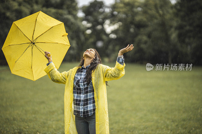 快乐的女人微笑着行走在雨天