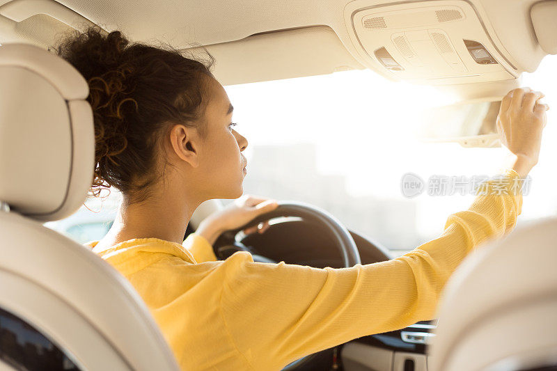 非洲妇女在试驾时调整后视镜检查汽车