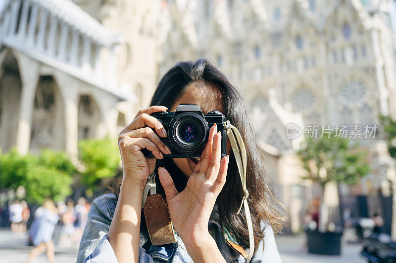 年轻女摄影师为度假拍摄对焦相机