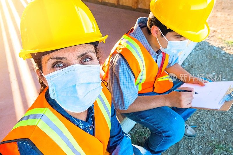 建筑工人戴着防护面罩坐在建筑工地