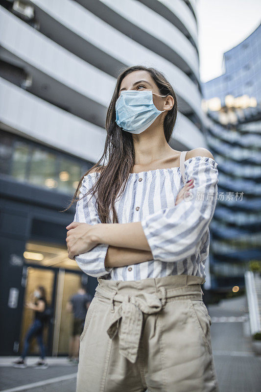 在新冠肺炎大流行期间，美丽的年轻女子戴着医疗脸在城市的肖像