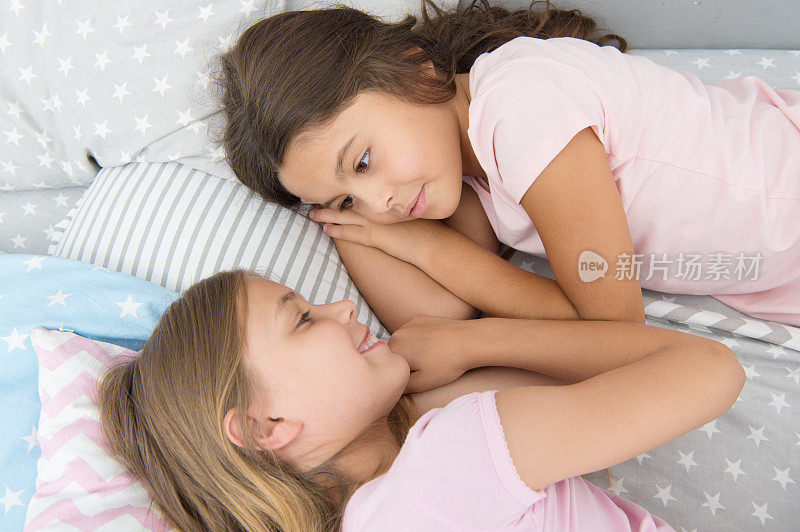孩子们的朋友。可爱的孩子睡觉前有空闲时间。对话最好的朋友。姐妹关系的概念。共享的秘密。孩子们在床上休息。姐姐准备睡觉。晚上好。最好的朋友