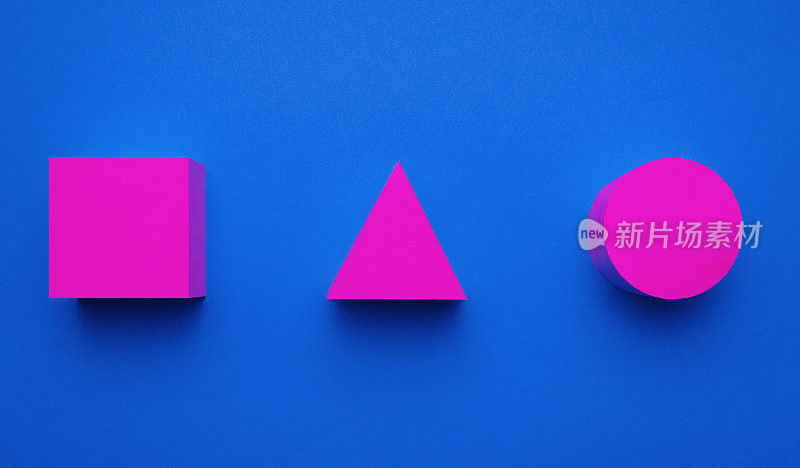 洋红色的圆形，三角形和正方形的纸在蓝色的背景。创造性的未来概念。