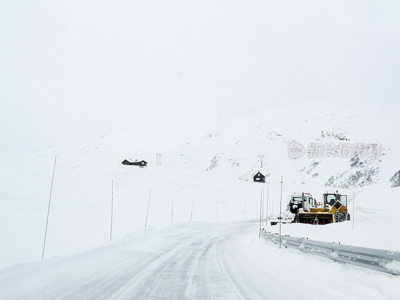 挪威，挖掘机铲雪车在雪道上工作。