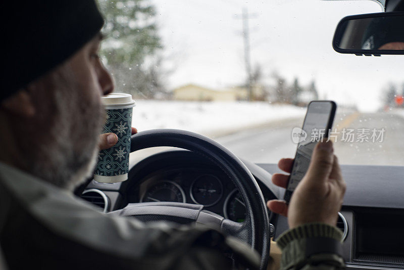 分心驾驶。一个拿着咖啡边开车边发短信的男人。