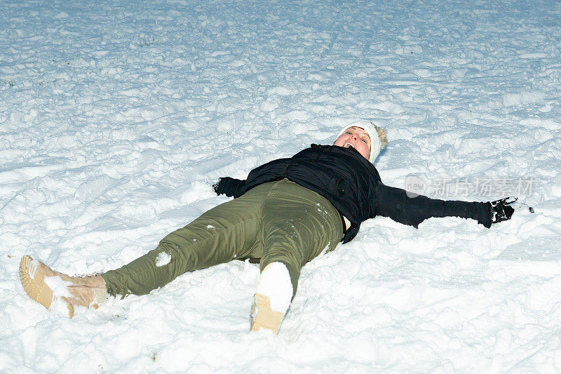 女士，躺在雪地上玩得开心