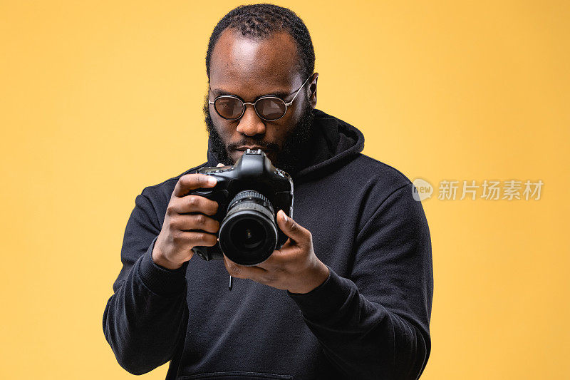 蓄着胡须的非裔美国专业摄影师职员在工作室里戴着眼镜。